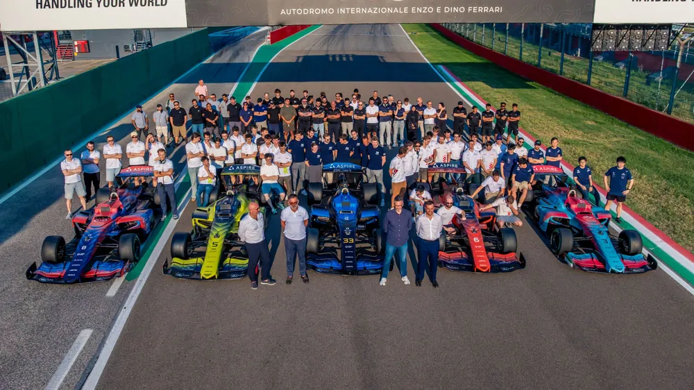The full A2RL grid of autonomous race cars and teams on the start straight at Imola